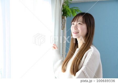 朝起きて朝日を浴びる女性　起床　睡眠改善　熟睡　健康習慣　 100689336
