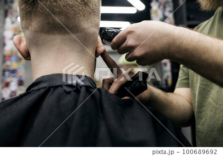 Barber cuts the mens hair Barber cuts the mens hair 100689692
