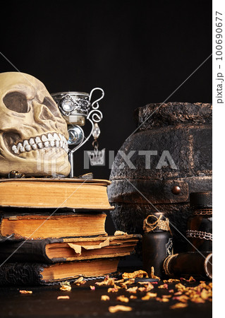 Realistic model of a human skull with teeth on a wooden dark table, black background. Medical science or Halloween horror concept. Close-up shot. Realistic model of a human skull with teeth on a wooden dark table, black background. Medical science or Halloween horror concept. Close-up shot. 100690677