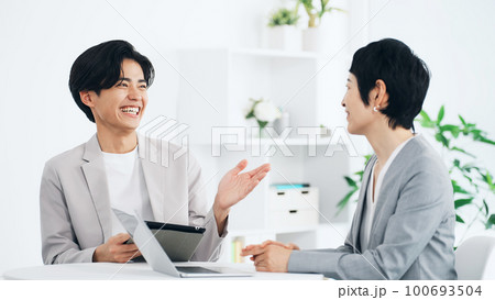 オフィスで会話するビジネスパーソン オフィスで会話するビジネスパーソン 100693504