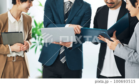 オフィスで会話するビジネスパーソンのグループ 100693515