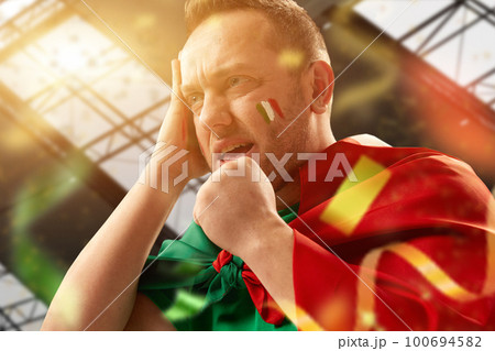 Tense moment. Football, soccer fan, mature man emotionally watching live match, competition. Worried face during game. Fans cheering up team Tense moment. Football, soccer fan, mature man emotionally watching live match, competition. Worried face during game. Fans cheering up team 100694582