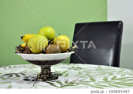 Juicy fruits in a bowl on the table 100695487