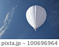 A Chinese-made white meteorological probe is shown flying in the sky, violating the airspace in its pursuit of atmospheric reconnaissance and research. 100696964