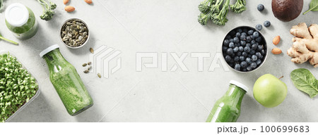 Vegetarian vegan healthy ingredients and green smoothie on grey stone background Vegetarian vegan healthy ingredients and green smoothie on grey stone background 100699683