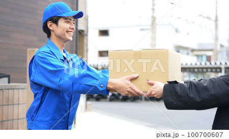 荷物を手渡す作業員　宅配便　デリバリースタッフ 100700607