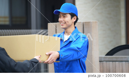 荷物を手渡す作業員　宅配便　デリバリースタッフ 100700608