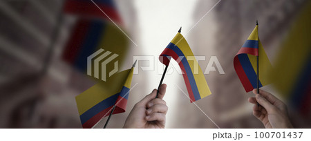 A group of people holding small flags of the Colombia in their hands 100701437