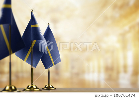 Small flags of the Nauru on an abstract blurry background 100701474