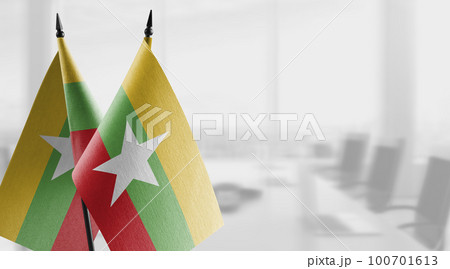 Small flags of the Myanmar on an abstract blurry background 100701613