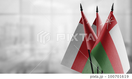 Small flags of the Oman on an abstract blurry background 100701619