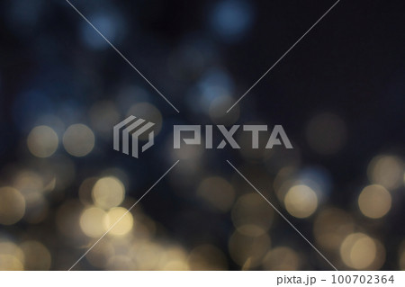 Blurred magic fairy lights with an abstract bokeh effect against a dark background 100702364
