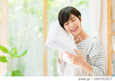 リビングで家事をする若い女性 100702927