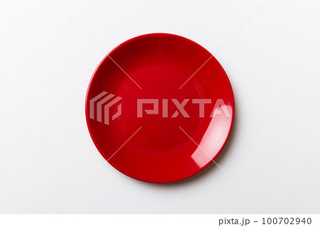 Top view of isolated of colored background empty round red plate for food. Empty dish with space for your design 100702940