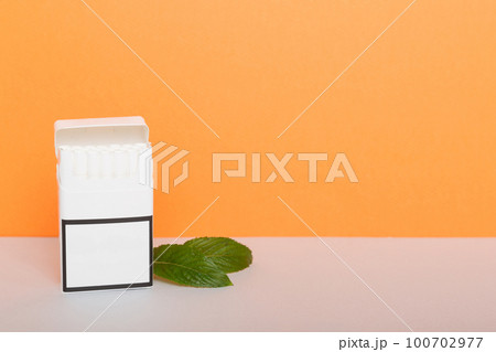Pack of menthol cigarettes and fresh mint on colored table, Menthol cigarettes top view flat lay 100702977