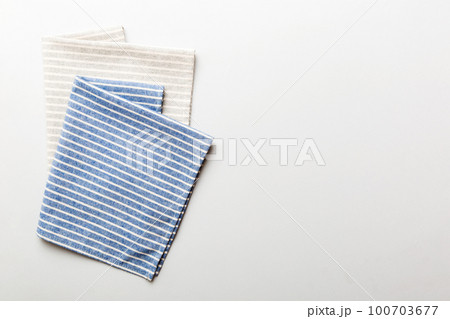 top view with blue kitchen napkin isolated on table background. Folded cloth for mockup with copy space, Flat lay. Minimal style top view with blue kitchen napkin isolated on table background. Folded cloth for mockup with copy space, Flat lay. Minimal style 100703677