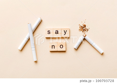 Cigarette And Wooden Blocks, Broken cigarette on table background, No Tobacco Day with hourglass, clock health concept. time to quit smoking Cigarette And Wooden Blocks, Broken cigarette on table background, No Tobacco Day with hourglass, clock health concept. time to quit smoking 100703728