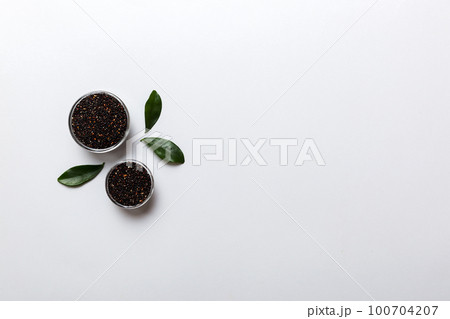 quinoa seeds in bowl on colored background. Healthy kinwa in small bowl. Healthy superfood 100704207