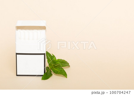 Pack of menthol cigarettes and fresh mint on colored table, Menthol cigarettes top view flat lay Pack of menthol cigarettes and fresh mint on colored table, Menthol cigarettes top view flat lay 100704247