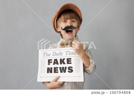 Newsboy shouting against grunge wall background. Boy selling fake news Newsboy shouting against grunge wall background. Boy selling fake news 100704808