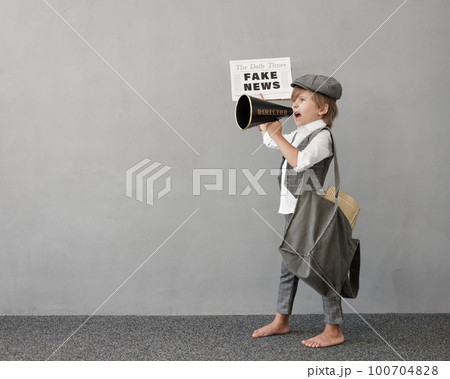Newsboy shouting against grunge wall background. Boy selling fake news 100704828