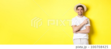 Young male tourist pointing finger right, smiling and showing advertisement, concept of tourism and lifestyle, yellow background Young male tourist pointing finger right, smiling and showing advertisement, concept of tourism and lifestyle, yellow background 100708425