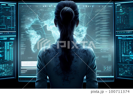 view from back to female student sitting at desk in front of monitor. 100711374