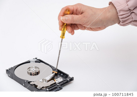 【HDDをドライバーで分解する女性】 100711845