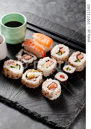 Homemade sushi rolls with salmon, shrimp, avocado. Served with soy sauce and ginger. 100712160