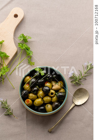 Black and green olives in a bowl. Delicious, marinated olives. Top view. 100712168