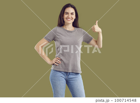 Happy cheerful young woman showing thumb up amiling at camera 100714548