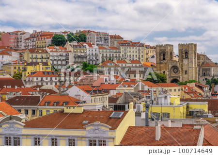 Lisbon, Portugal panoramic landscape of 12th-century Lisbon Cathedral, Se De Lisboa, surrounded by traditional low-rise red tile rooftop buildings. Lisbon, Portugal panoramic landscape of 12th-century Lisbon Cathedral, Se De Lisboa, surrounded by traditional low-rise red tile rooftop buildings. 100714649