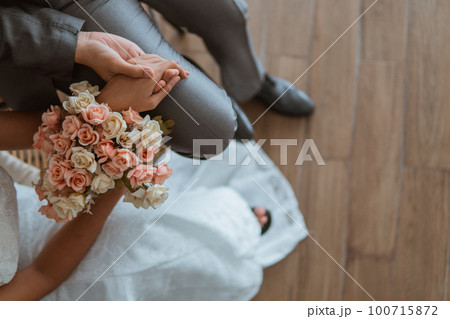 asian brides sitting on the chair together and holding hand 100715872