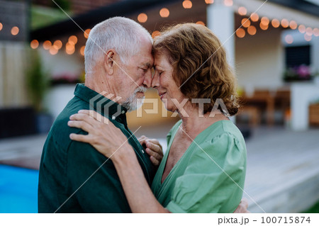 Senior woman nad man dancing together in a garden in summer 100715874