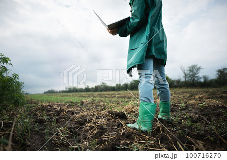Farmer with laptop on the field.  100716270