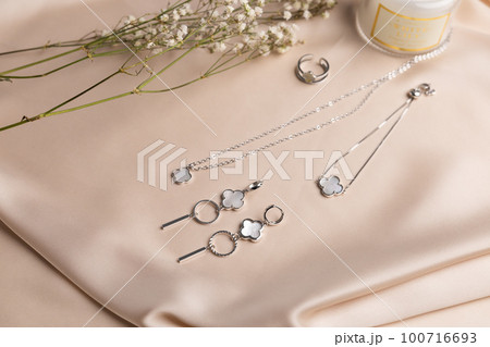 Bracelet and earrings and chain made of natural pearl and silver. Natural mineral texture jewellery. Bijouterie and handmade accessories top view elegant background Bracelet and earrings and chain made of natural pearl and silver. Natural mineral texture jewellery. Bijouterie and handmade accessories top view elegant background 100716693