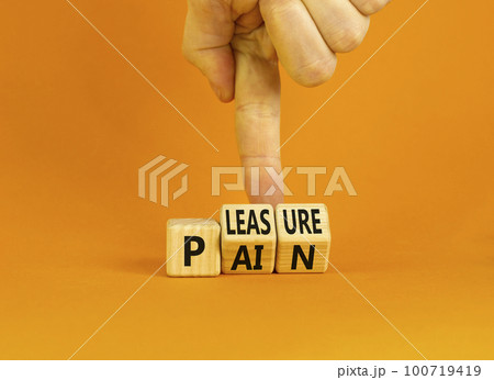 Pain or pleasure symbol. Concept words Pain or Pleasure on wooden cubes. Businessman hand. Beautiful orange table orange background. Business and pain or pleasure concept. Copy space. 100719419