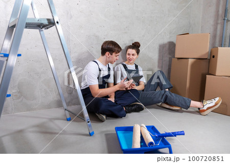 Couple in new home during repair works discussing about home design project looking repair plan on tablet. Happy family choosing new decorations and design. Home renovation DIY renew makeover concept Couple in new home during repair works discussing about home design project looking repair plan on tablet. Happy family choosing new decorations and design. Home renovation DIY renew makeover concept 100720851