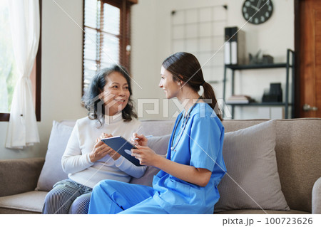 Portrait of a female doctor holding tablet computer to discuss and analyze the patient's condition before treating 100723626