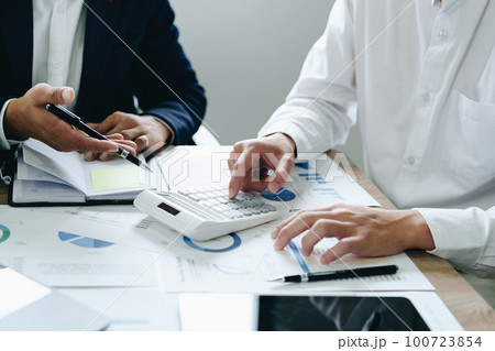 financial, Planning, Marketing and Accounting, Asian young Economist using calculator to calculate investment documents with partners on profit taking to compete with other companies 100723854