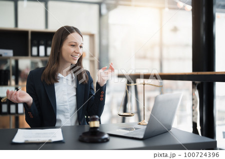 Portrait of a Asian woman lawyer studying lawsuit a for a client using computer laptop , documents to video conference before going to court 100724396