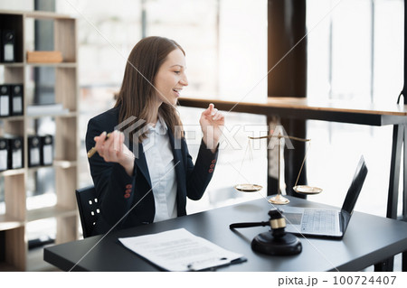 Portrait of a Asian woman lawyer studying lawsuit a for a client using computer laptop , documents to video conference before going to court 100724407