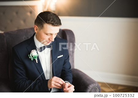 Beautiful man, groom posing and preparing for wedding 100725332