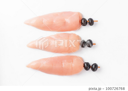 raw chicken inner on skewers with olives on a white background.Raw uncooked Chicken meat, kebab on skewers on a white background .skewers of raw meat and vegetables. 100726768