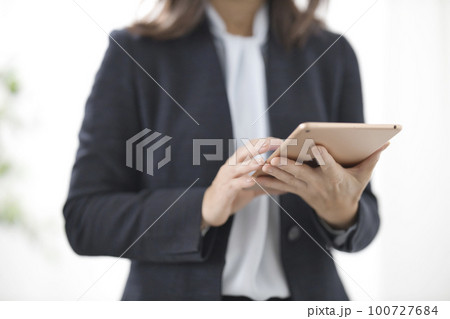 タブレットを操作するビジネスウーマンの手元 タブレットを操作するビジネスウーマンの手元 100727684