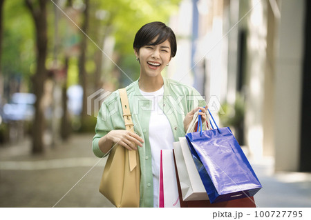 買い物を楽しむ笑顔の若い女性 買い物を楽しむ笑顔の若い女性 100727795