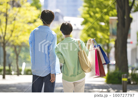 買い物を楽しむ若いカップルの後ろ姿 100727797