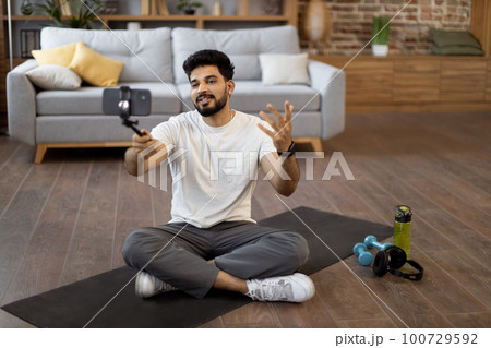 Fitness blogger having personal training online via phone 100729592