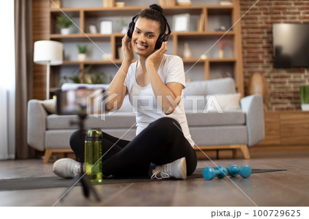 Active lady recording workout video for sport vlog via phone Active lady recording workout video for sport vlog via phone 100729625