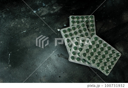 Chlorella or spirulina tablets on dark background 100731932